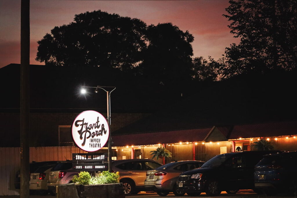 Nighttime shot of Front Porch Improve with a pink sunset visible in the background of the building