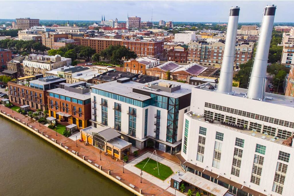 Aerial view of Savannah's Plant Riverside District, with two old smokestacks visible atop the roof of one of the buildings