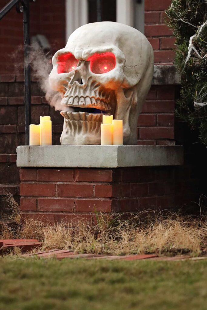 A giant skull with red eyes and smoke coming from the mouth sits on the porch of an Ardsley Park home