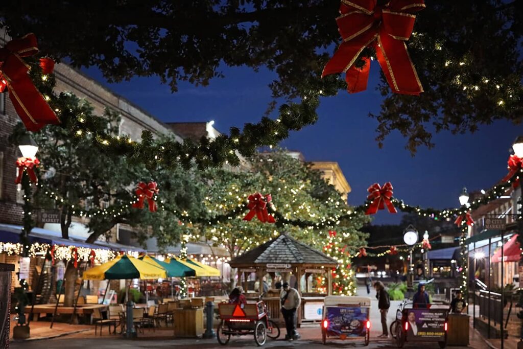 Christmas scene in Savannah's City Market with twinkle lights and garlands draped from one side of the market to the other