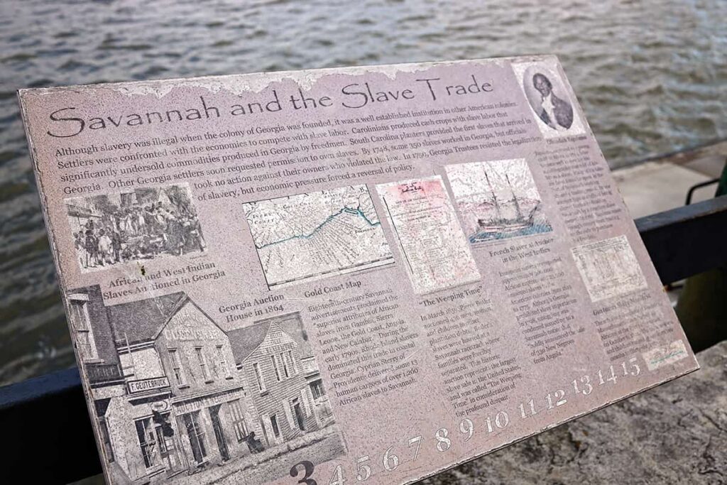 Historic marker about the slave trade in Savannah with the river visible in the background