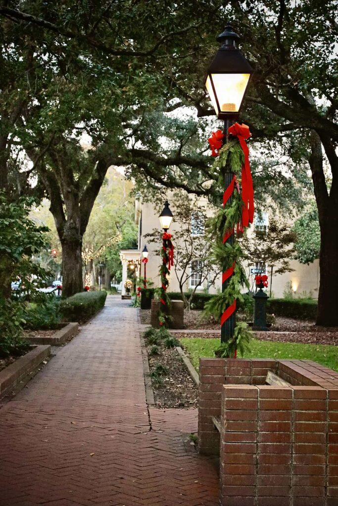 Gas lanterns in Troup Square adorned for Christmas with live greenery and red ribbons