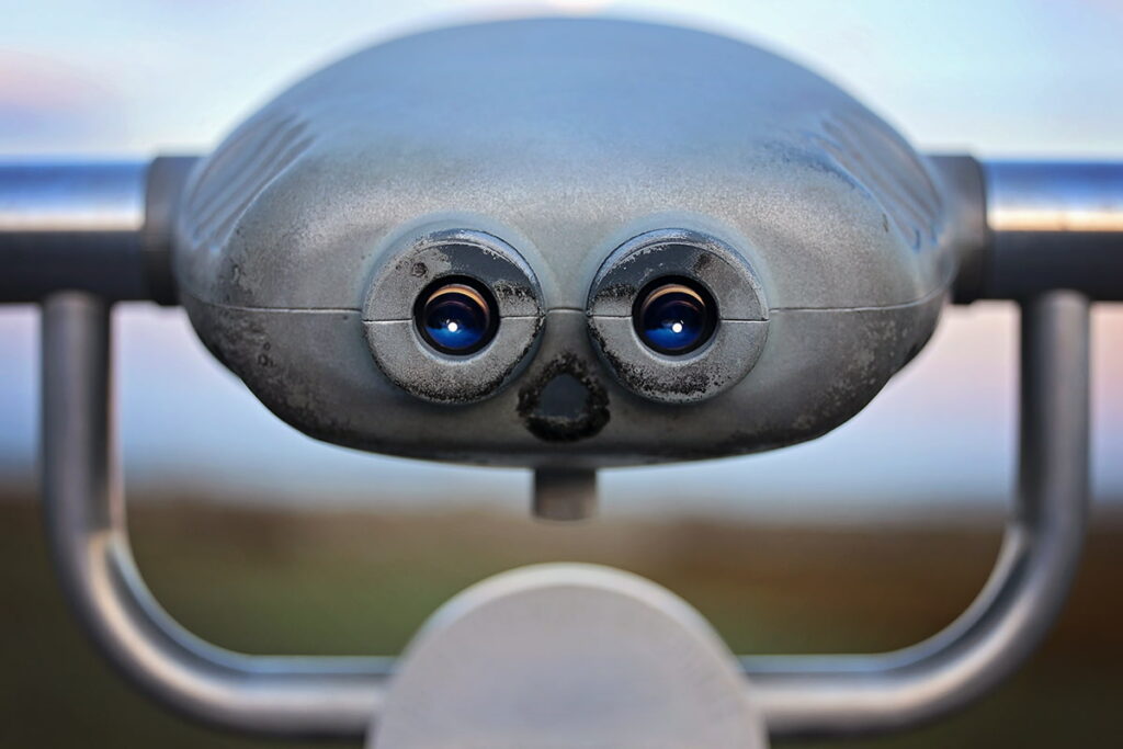 This pareidolia-style image of a Hi-Spy Viewfinder resembles an angry cartoon metal robot with tiny white dots in its "eyes" from the reflection of the full moon over the beach