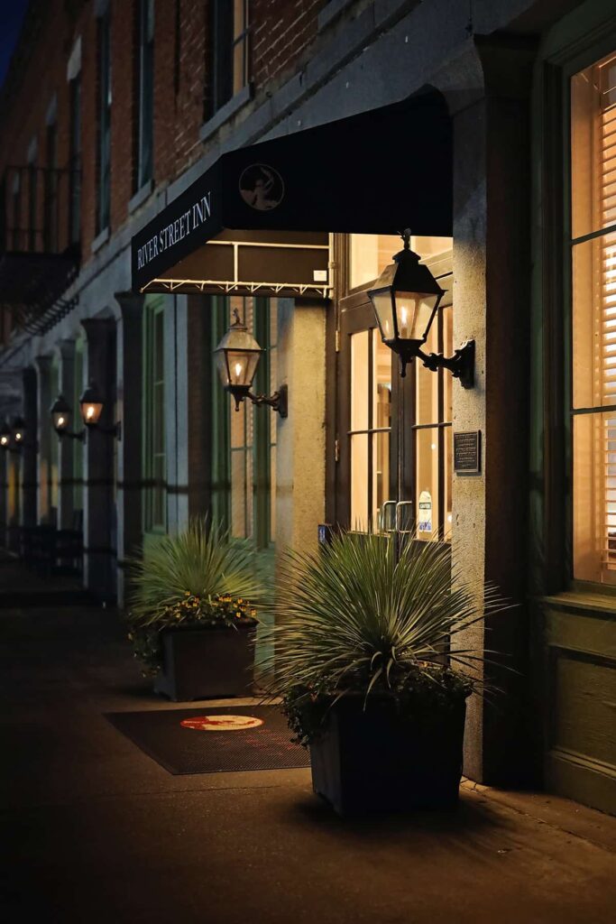 Entrance to a hotel on River Street with two gas lanterns illuminating the doorway