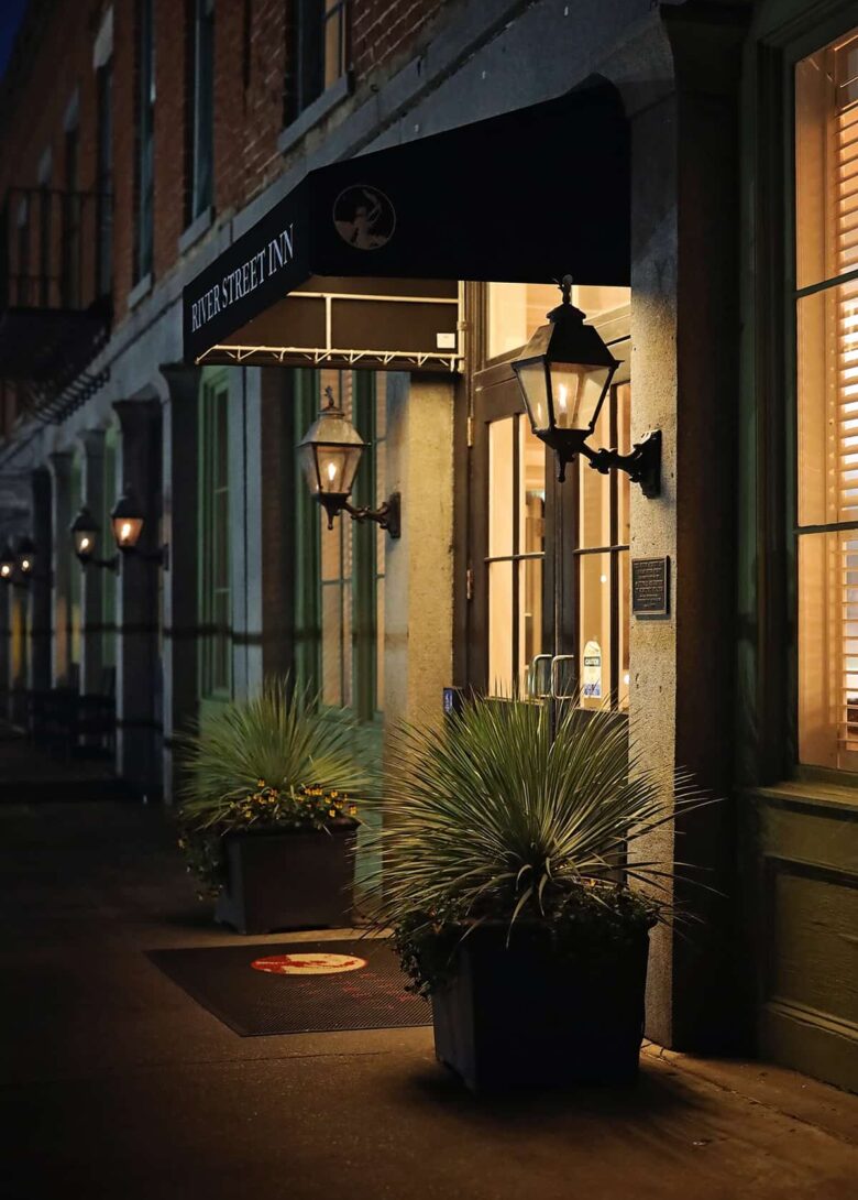 Entrance to a hotel on River Street with two gas lanterns illuminating the doorway