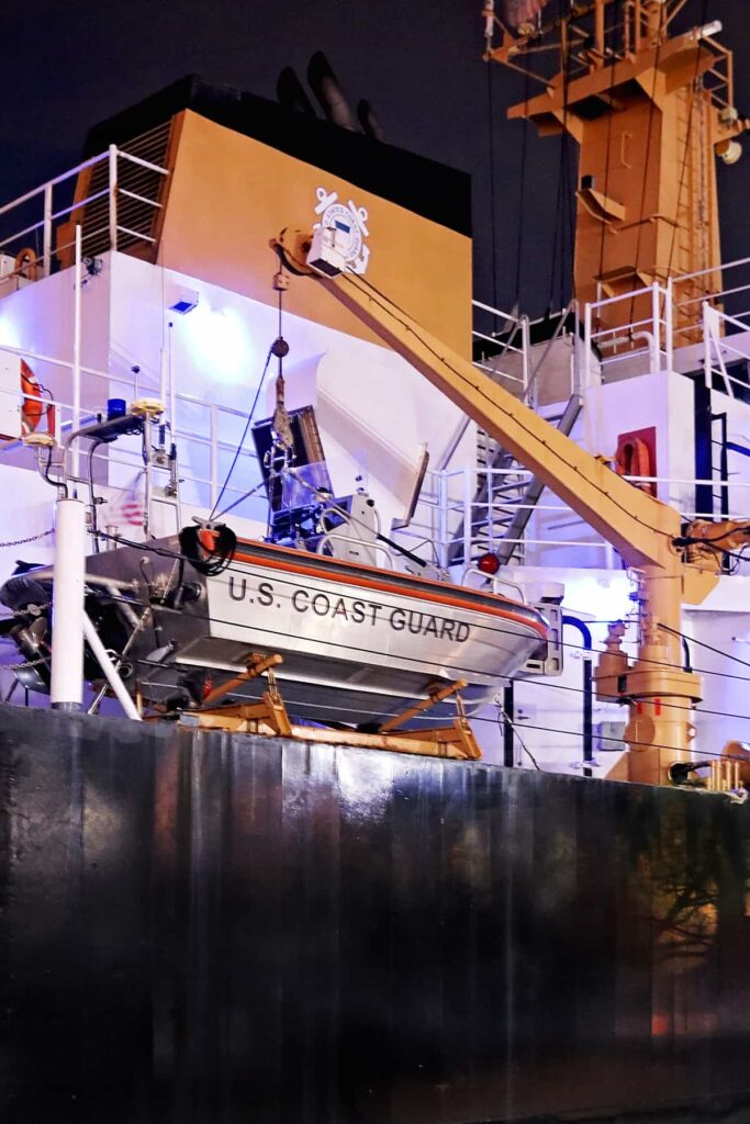 A U.S. Coast Guard rescue boat attached to a yellow crane aboard the Joshua Appleby