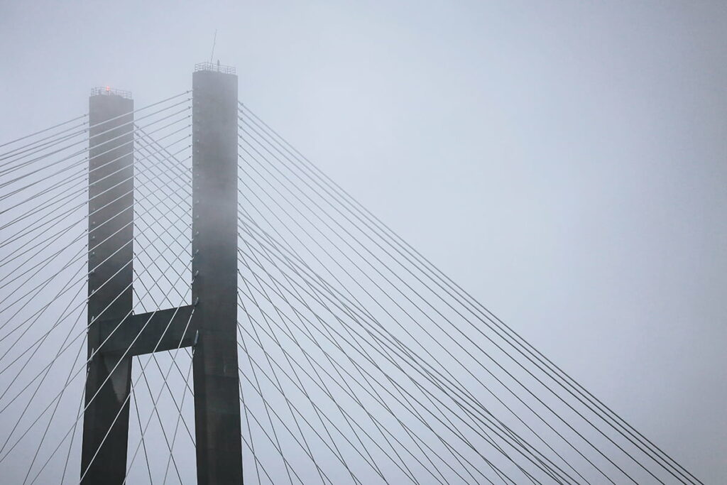 Fog settles over the Talmadge bridge in Savannah, partially obscuring the tallest points of the structure