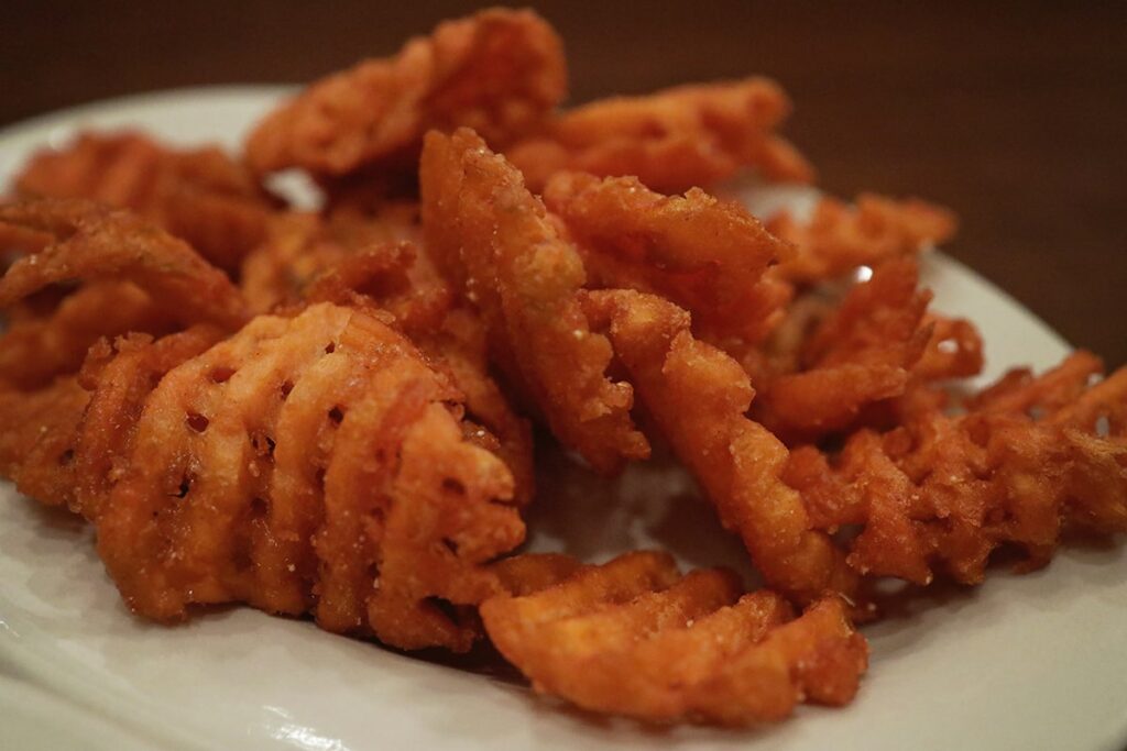 Plate full of crisp golden-fried sweet potato fries from Crystal Beer Parlor in Savannah