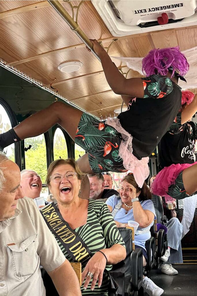 Passengers on the Savannah for Morons trolley tour laugh uncontrollably as two of the "morons" hang from the ceiling