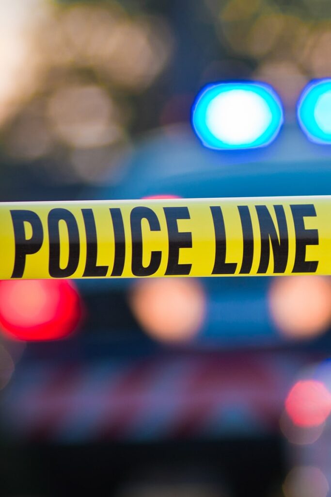 Savannah crime map 2026 with yellow police tape and blurred red and blue police lights in the background